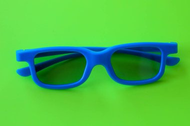 Lacivert yeşil arka planda duran mavi plastik gözlüklü parlak bir kare. Aksesuar ve zıt renk kombinasyonunun minimalist tasarımı yaz tatili için mükemmel, modern ve enerjik bir imaj yaratır.,