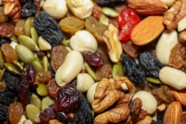 Besleyici fındık, kurutulmuş meyve ve balkabağı tohumlarının çeşitli karışımları sağlıklı beslenmek için canlı dokulu bir bileşim oluşturur. En üstteki görüntüde bol miktarda badem, ceviz, kuru üzüm ve şekerli meyve var. Enerjik bir atıştırmalık için mükemmel..