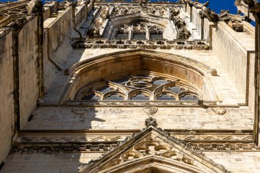 York, İngiltere 'de gün ışığıyla aydınlatılan, karmaşık gotik mimari detaylarla dolu, taştan bir katedralin alçak açılı, tam kare görüntüsü..