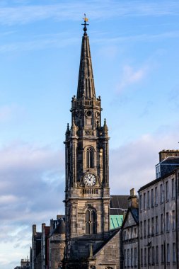 Uzun, taştan bir saat kulesi merkeze hükmediyor. Tepesinde rüzgar gülü olan bir kule var. Değişen yükseklik binaları Edinburgh, İskoçya 'da sağda..