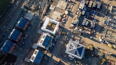 Kısmen inşa edilmiş evler, iskeleler, ağır makineler ve İngiltere 'nin Leeds kentindeki Strata Homes' un Desire 'da yapım aşamasında olan çeşitli yapı malzemelerinin bulunduğu bir inşaat alanının havadan görüntüsü..