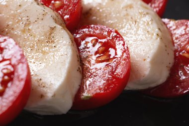 Dilimlenmiş mozzarella, sulu domatesler, zeytinyağı ve karabiberden yapılmış taze İtalyan caprese salatası. Temiz ve sağlıklı Akdeniz yemeği, diyet ve restoran kavramları için mükemmel..