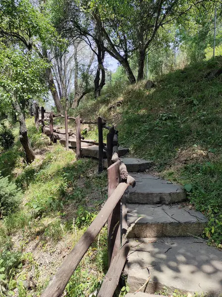 Kolayca yürümek için tahta parmaklıklarla taş basamaklar, güneşli bir günde yazın çekilmiş fotoğraflar. 
