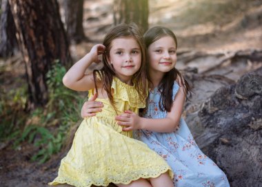 İki küçük kız arkadaş ormanda sarılıyor, arkadaşlık konsepti, yaz zamanı.