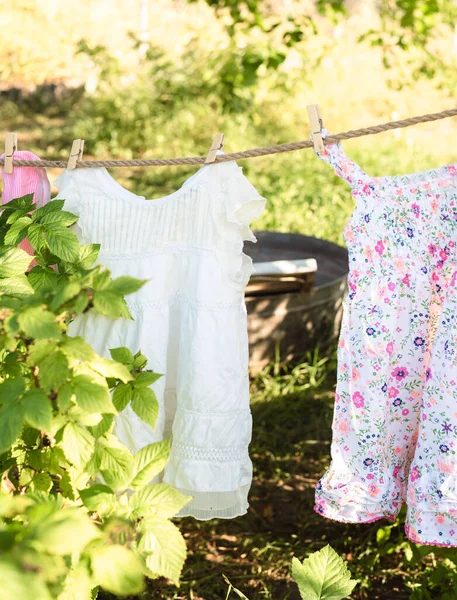 Laundry in the garden, washed clothes for children dry on a rope in the garden. Eco concept, laundry