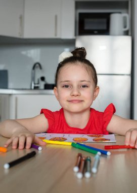 Genç liseli kız evde mutfakta paskalya süsleri ve yumurta çiziyor. Paskalya için dekoru kız kendisi çiziyor ve oyuyor..