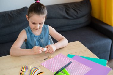 Anaokulundaki bir kız renkli titreşimler, çocuklar için yaratıcılık, karantinadaki bir çocuk için aktiviteler yapıyor..