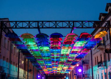 Akşamları renkli şemsiyeler. Gökyüzünde renkli şemsiyeler. Şemsiyelerden sokak dekorasyonu. Şemsiyelerin arka planı.
