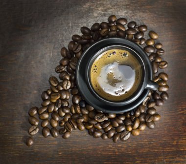 Tahta arka planda bir fincan sıcak kahve.