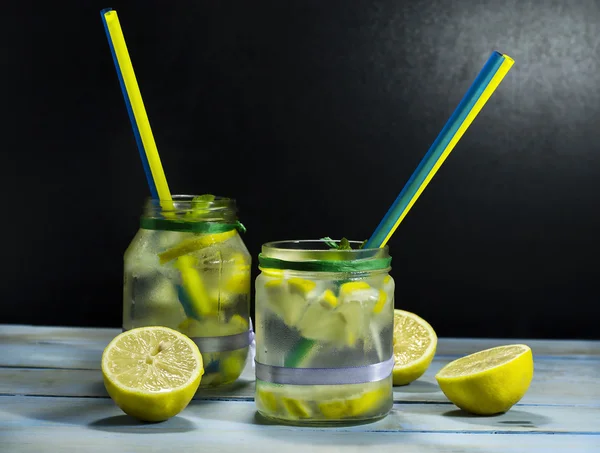 Limonada fría en botellas con limones —  Fotos de Stock