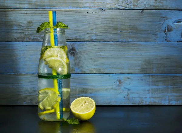 Холодний лимонад в пляшках з лимонами — стокове фото