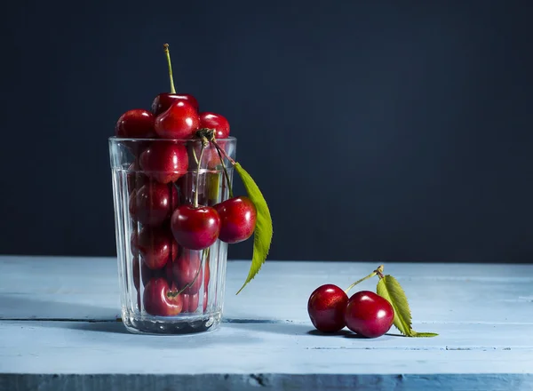 Cherries on a blue wooden background. — Stock Photo, Image