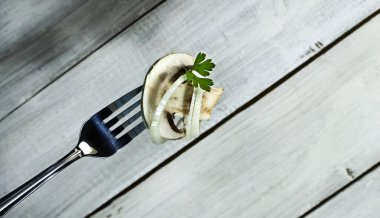 Soğan ve maydanoz üzerinde bir çatal ile taze mantar.