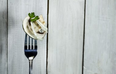 Soğan ve maydanoz üzerinde bir çatal ile taze mantar.