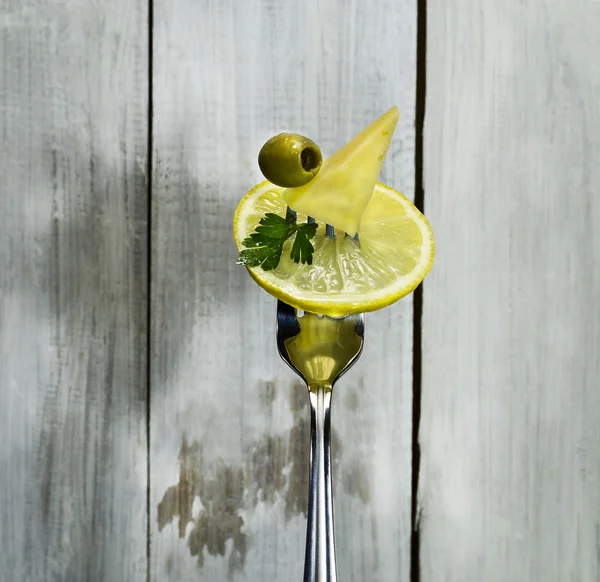 Лимон, сир, оливки, червоний перець і петрушка на виделці . — стокове фото
