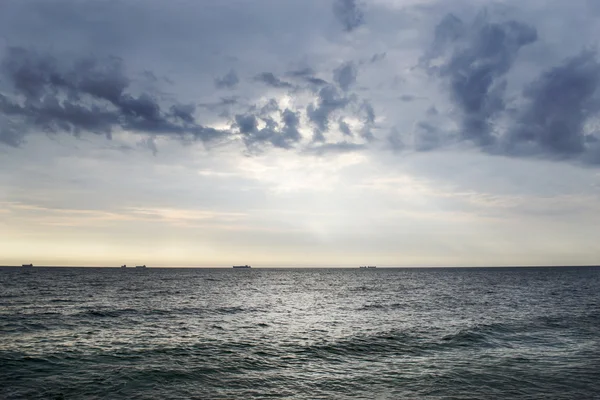 Krajina s lodí na obzoru a zamračená obloha — Stock fotografie