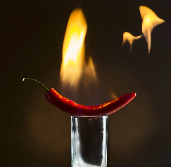 Красный перец с пламенем на стекле — стоковое фото