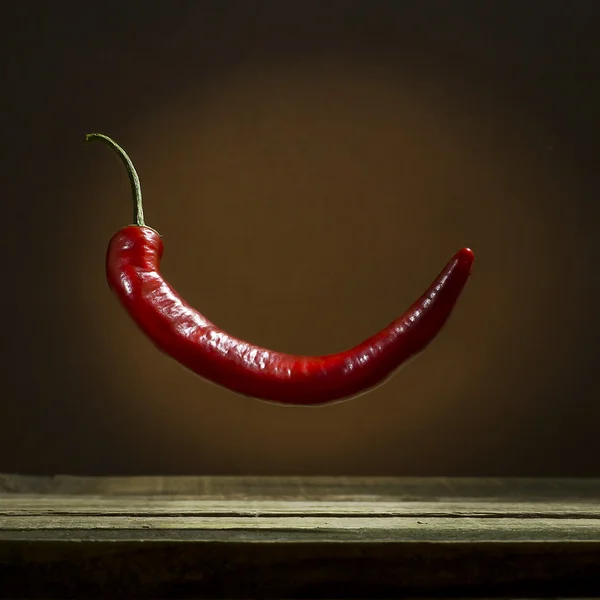 Pimenta quente vermelha em um fundo marrom — Fotografia de Stock