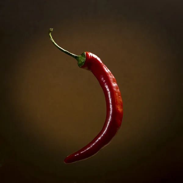 Pimenta quente vermelha em um fundo marrom — Fotografia de Stock