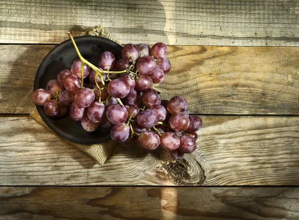 Букет стиглого винограду на тарілці, і мішковини . — стокове фото