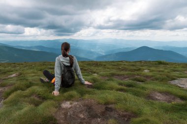 Sırt çantalı bir kız güzel dağlara bakıyor. Yürüyüş. Spor..