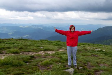 Woman with outstretched arms on a beautiful mountain. Tourism. Travels.