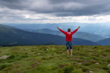 A man with outstretched arms on a beautiful mountain. Success. Tourism. Travels.