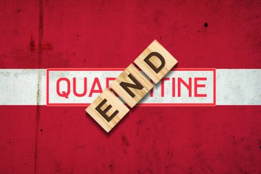 Karantina sona erdi. Letonya bayrağının arka planındaki tahta bloklardaki yazı. Salgının sonu geldi. İş için. Seyahat