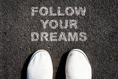 Hayallerinin peşinden git. Yolun aşağısında yazıyor. Sneakers. Süper manzara. Hedefe ulaşma başarısı. İş dünyası.