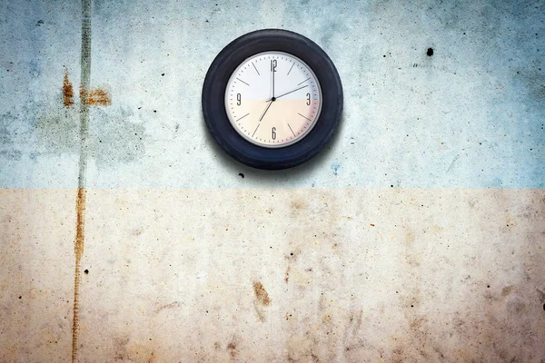 Beton bir duvardaki araba tekerleğindeki saat. Araba lastiği konsepti. Uzayı kopyala İş için. Araba servisi. Arkaplan.