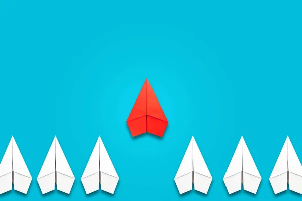 红色的纸飞机在一群白人面前飞行 蓝色背景 复制空间 领导理念 团队合作 人事管理 生活方式 — 图库照片