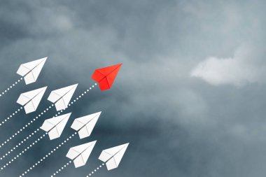 Bir grup beyazın önünde uçan kırmızı kağıt uçak. Bulutlu gökyüzü. Liderlik konsepti, takım çalışması, personel yönetimi. İş için. Yaşam tarzı. Arkaplan.
