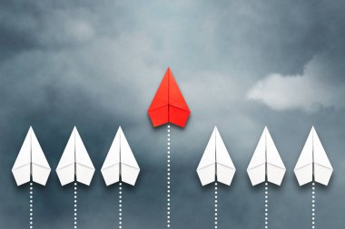 Bir grup beyazın önünde uçan kırmızı kağıt uçak. Bulutlu gökyüzü. Liderlik konsepti, takım çalışması, personel yönetimi. İş için. Yaşam tarzı. Arkaplan.