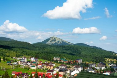 Dağın eteğindeki kır evleri ve otellerin manzarası güzel. Ukrayna. Bukovel. Karpatlar. Yaz tatili. Turizm. Seyahat.