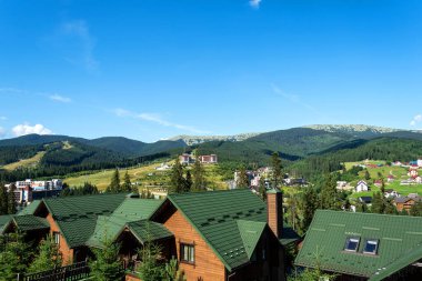 Dağın eteğindeki kır evleri ve otellerin manzarası güzel. Ukrayna. Bukovel. Karpatlar. Yaz tatili. Turizm. Seyahat.