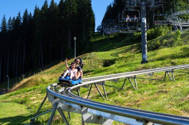 Bukovel. Ukrayna. - Dokuz. Ağustos. 2020 yılı. Speed Fan kaydırağında mutlu genç bir çift. Eğlence. Karpatlar. Yaz tatili turizmi