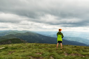 İnsanlar dağın tepesindeki dağlara bakıyorlar. Yürüyüş turları. Turizm. Spor. Seyahat et. Arkaplan.