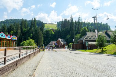 Bukovel. Ukrayna. 17. Temmuz. 2021 yılı. Tatil köyünün güzel sokakları, dağların arka planına karşı. Karpatlar. Yaz tatili gezileri