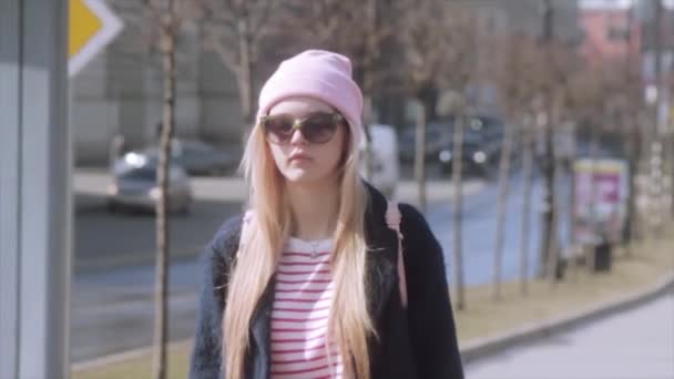 Hermosa joven está caminando en una hermosa calles soleadas. Movimiento lento — Vídeos de Stock