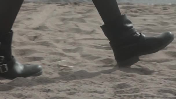 Schlanke Beine des Mädchens, das in schwarzen Schuhen am Strand spazieren ging — Stockvideo