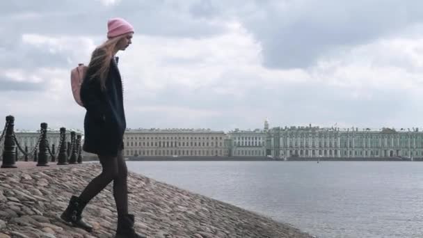 Adolescente descend à l'eau sur un talus de pierre — Video