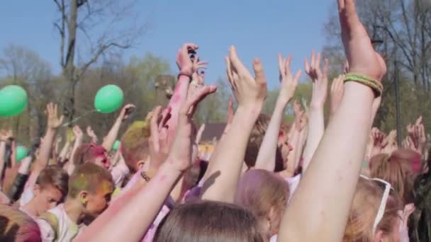 SAINT-PETERSBURG, RUSSIA - MAY 3, 2016. Holi Festival of colors. Teens raise their hands up — Stock Video