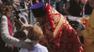 Ortodoks rahip kutsal su insanlara sprinkles. Bisikletçileri geçit ve gösteri.