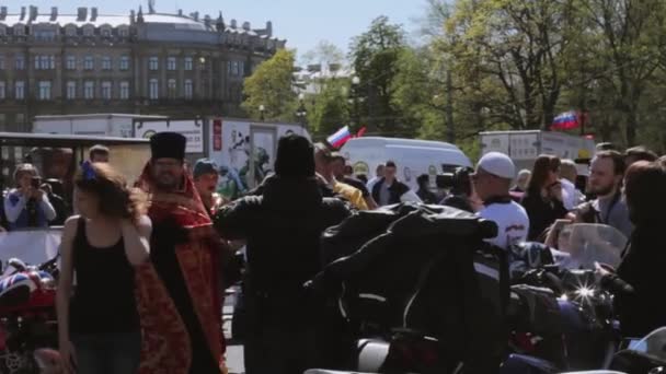 Orthodoxe priester hagelslag wijwater aan mensen. Fietsers parade en Toon. — Stockvideo