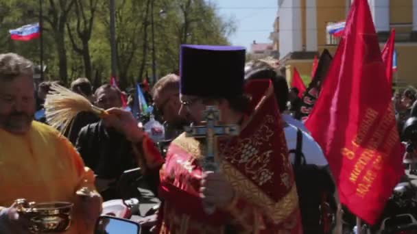 Orthodoxe priester hagelslag wijwater aan mensen. Fietsers parade en Toon. — Stockvideo