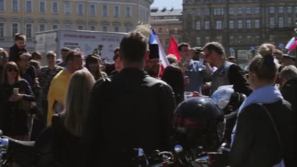 Sacerdote ortodosso spruzza acqua santa alla gente. Sfilata e spettacolo dei motociclisti . — Video Stock