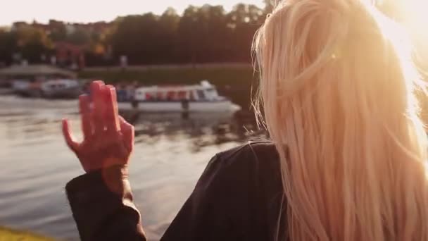 Молодая девушка машет рукой лодка, проходящая вдоль реки — стоковое видео
