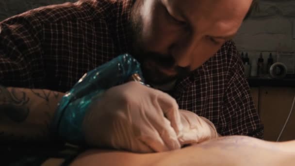 Tattoo meester met baard een tatoeage van mandala patroon te maken. Close-up shot — Stockvideo
