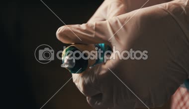 Ekose gömlek prepearing dövme makinesi iş için adam. Elinde lastik eldiven, yakın çekim