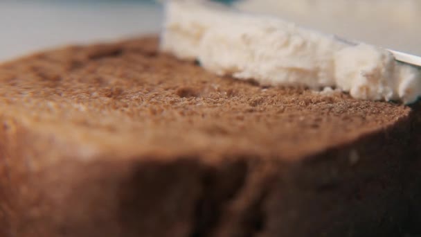 Boter mes wrijft boter of kwark op stuk brood. Tilt-shift — Stockvideo